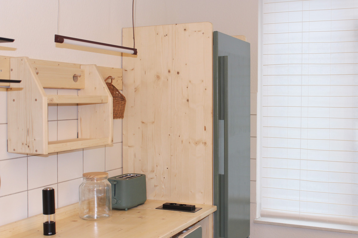 Arbeitsplatte in Holz und grüner Kühlschrankfront