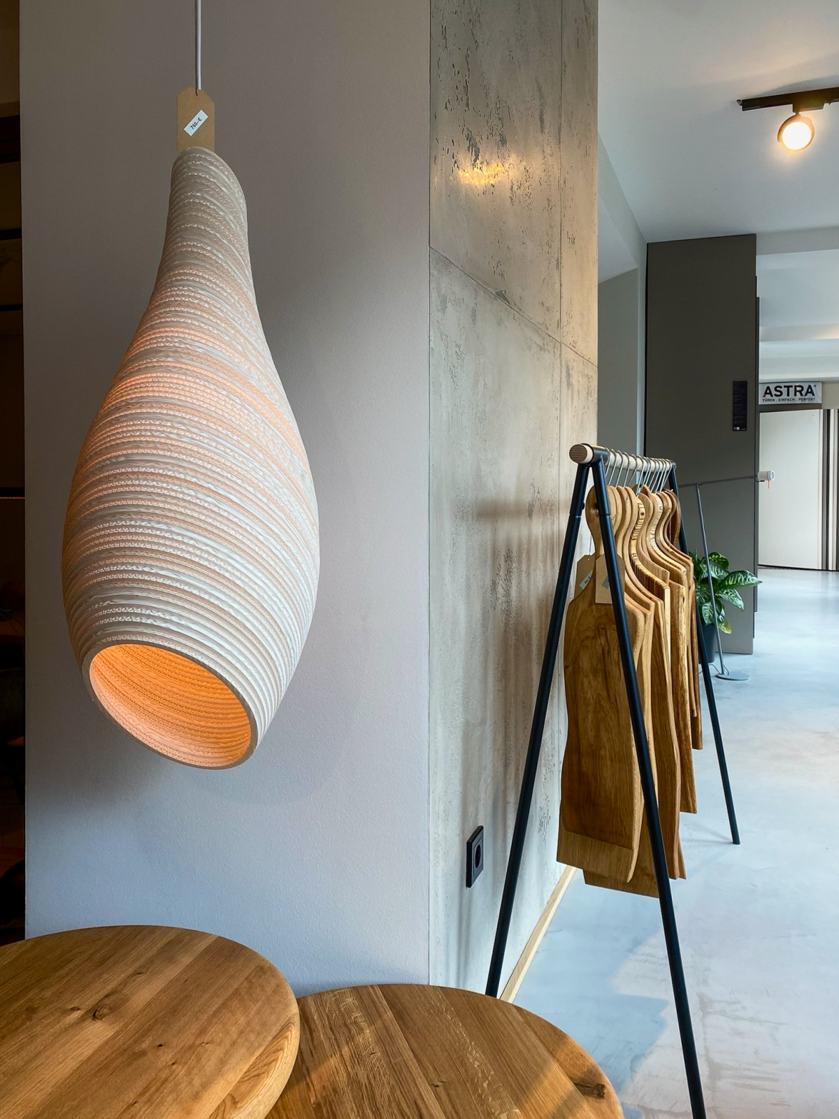 Akzentwand mit Leuchte und Tapas Brettchen und Holztischen