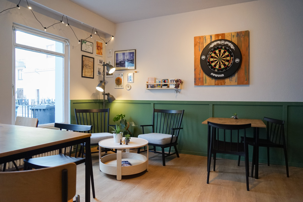 Sitz- und Loungebereich mit grüner Vertäfelung und Dart